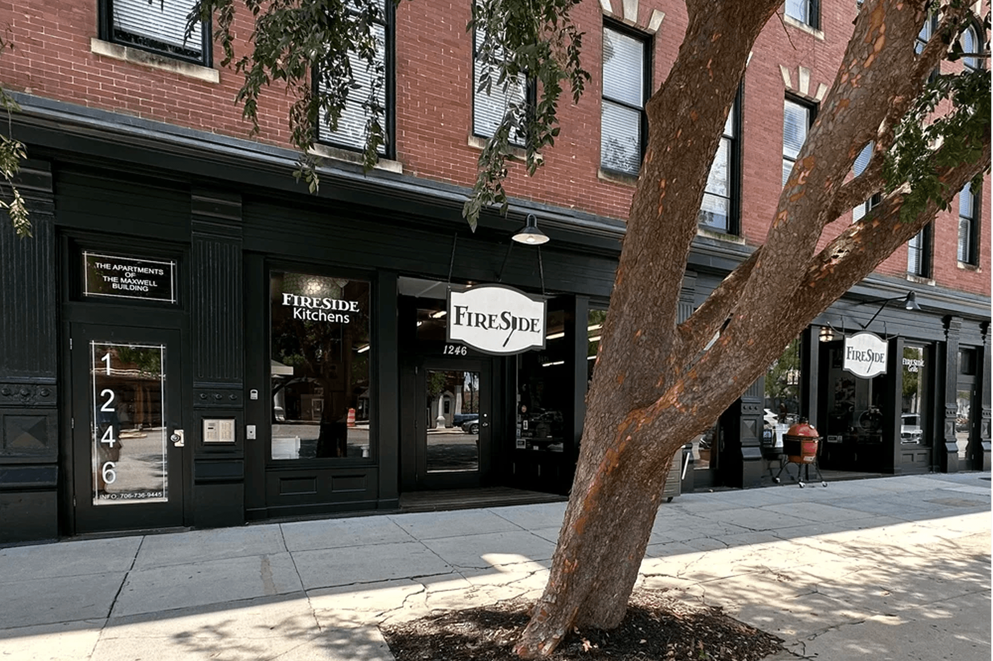 Fireside Kitchens storefront in historic brick building with outdoor grills visible.